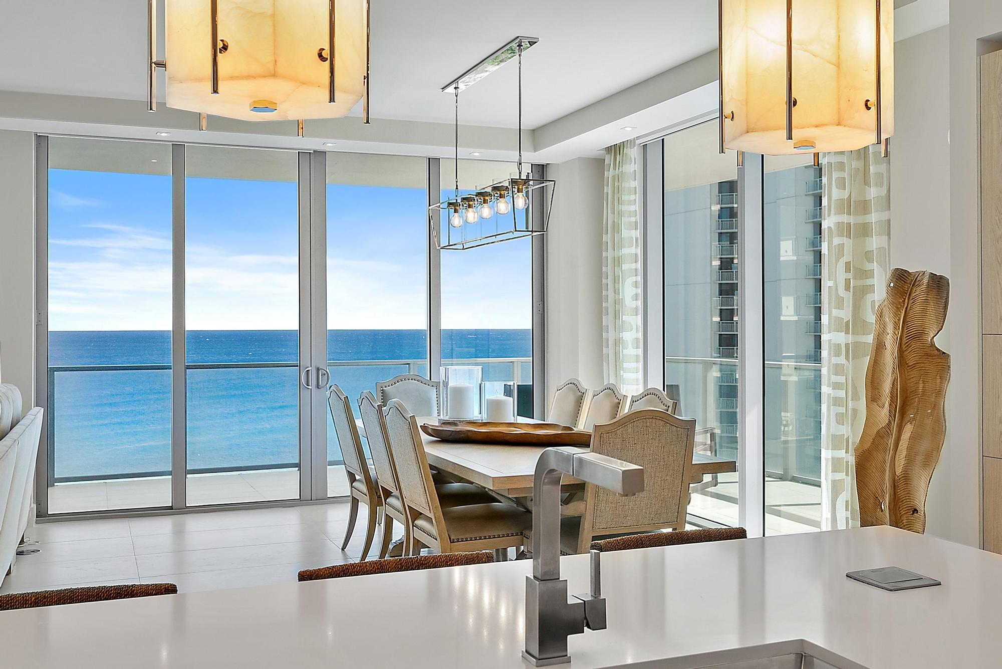 a dining room with furniture and a floor to ceiling window