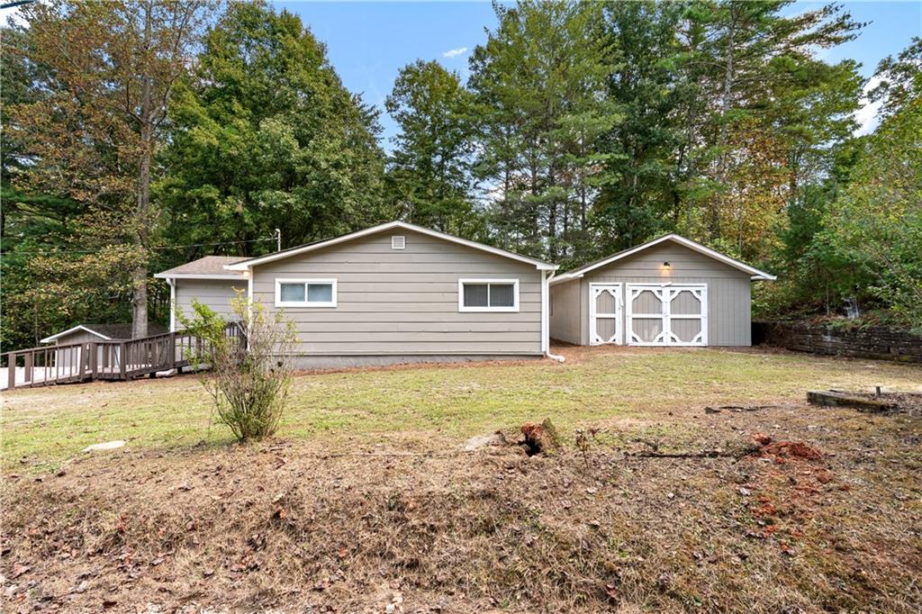 a view of a house with backyard and trees