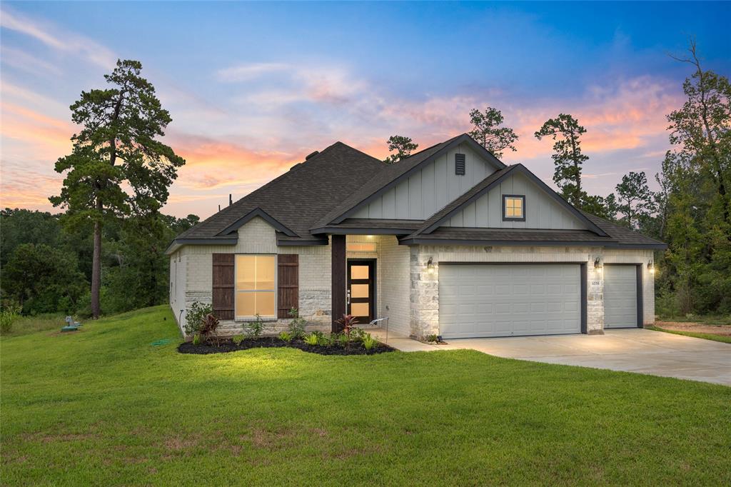 Nestled amidst towering trees and offering stunning sunrise lake views, this modern single-story home is a true oasis. Its sleek design features a blend of brick, stone and hardy plank, a spacious three-car garage, and a beautifully landscaped front yard. Experience the perfect blend of modern aesthetics and natural tranquility.