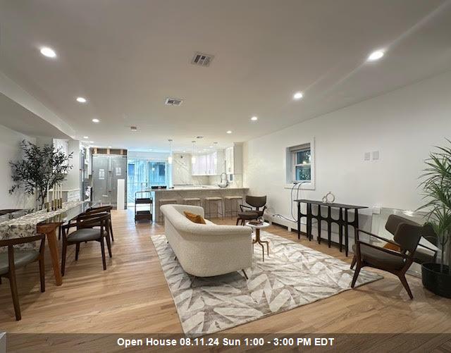 a living room with a couch and a dining table with wooden floor