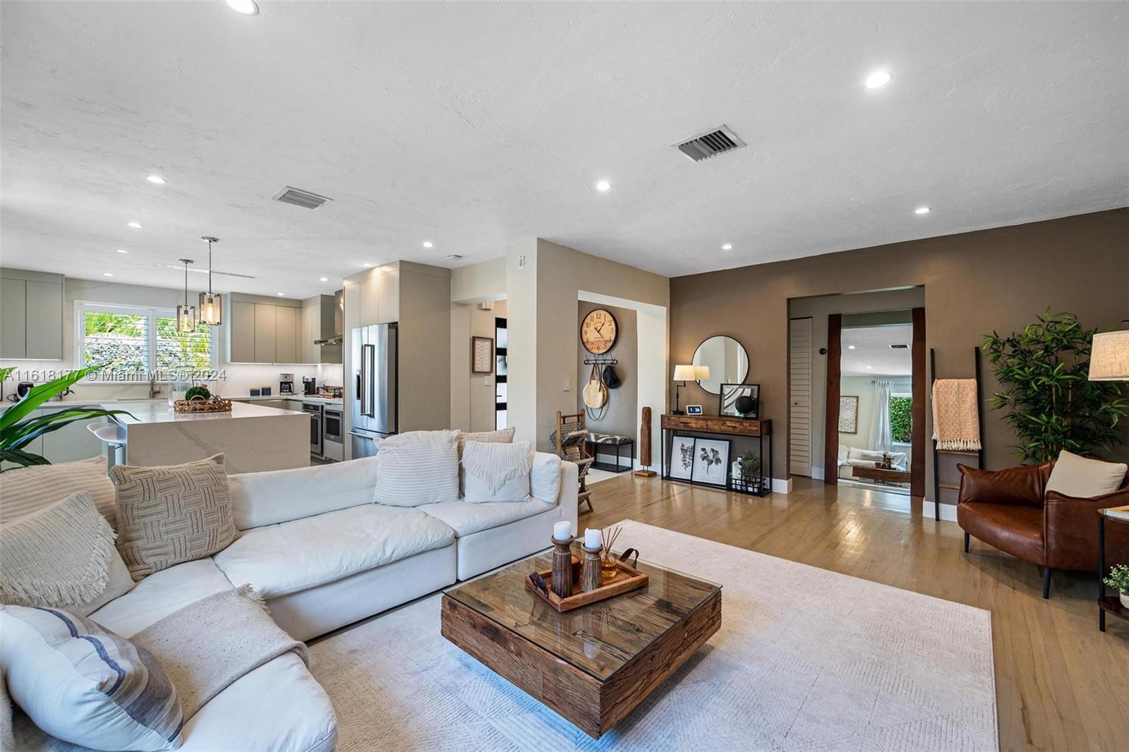 a living room with furniture kitchen view and a large window