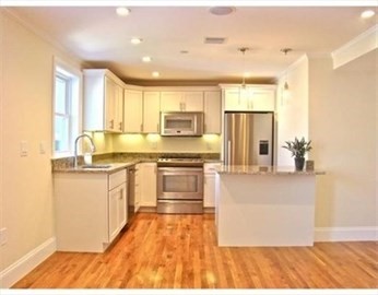 a kitchen with granite countertop a stove a sink and a refrigerator