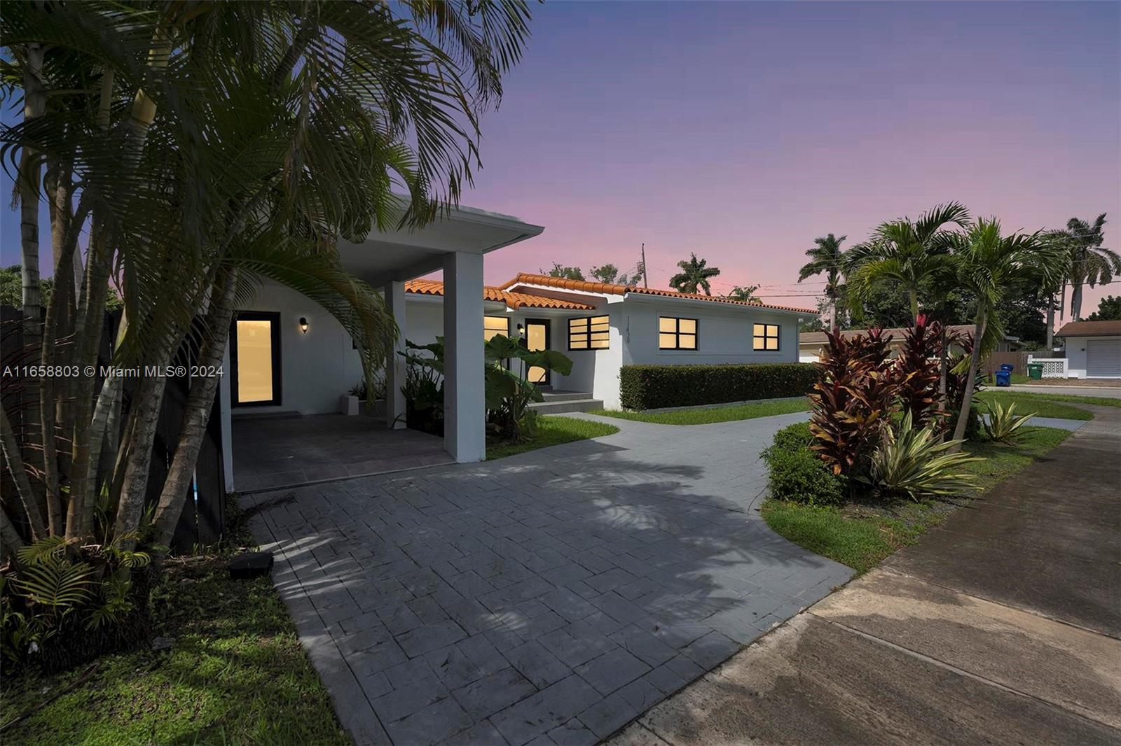 a front view of a house with a yard and green space