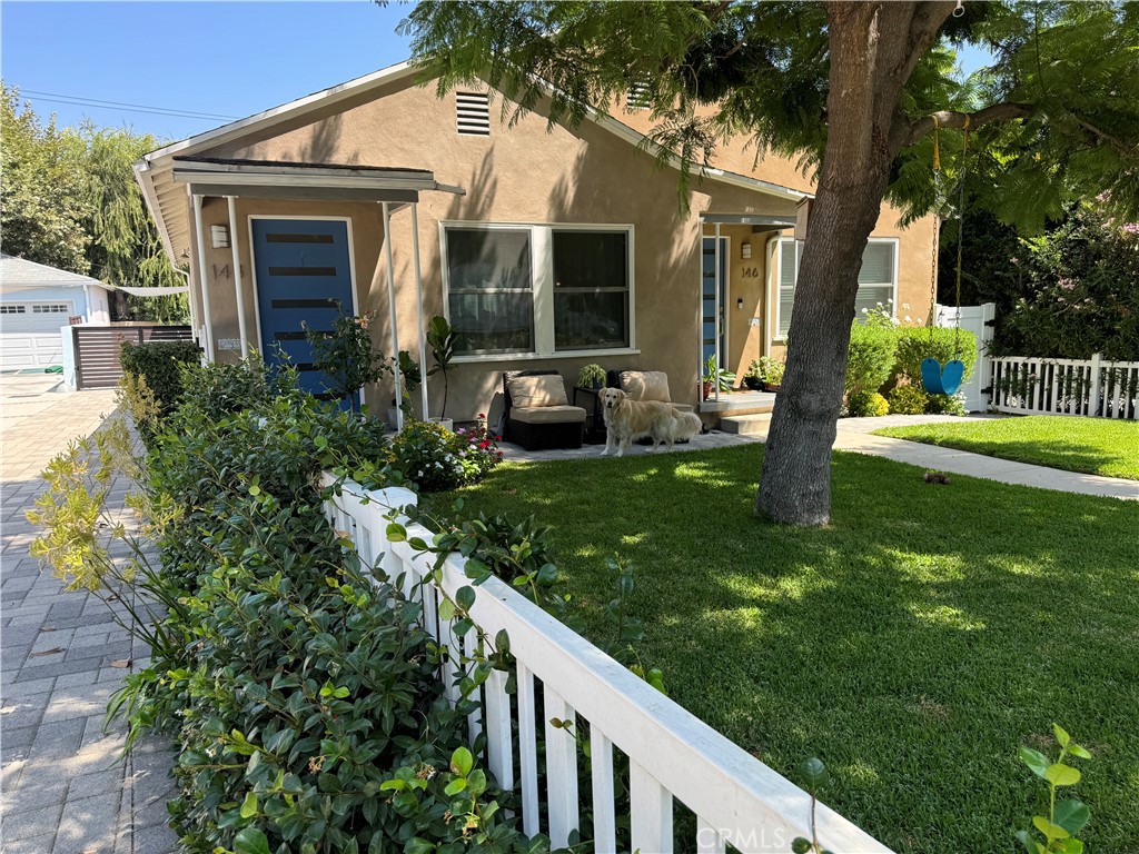 a view of a house with backyard and sitting area