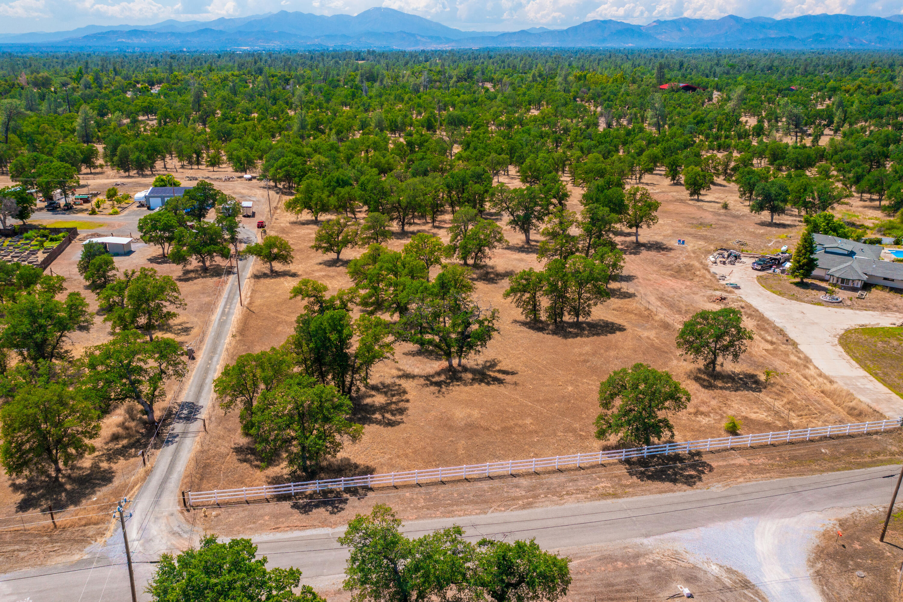 an aerial view of residential house with yard and mountain view in back