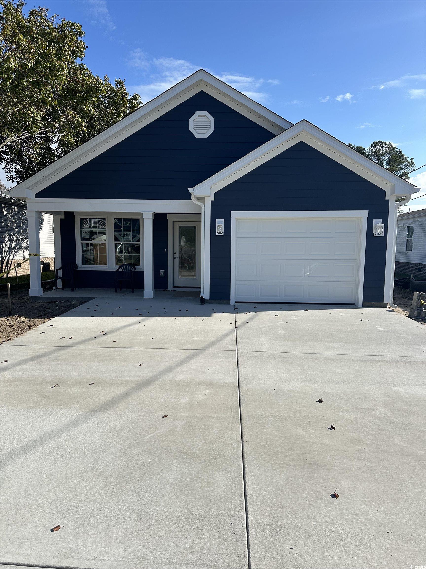 View of front of house featuring a porch and a gar