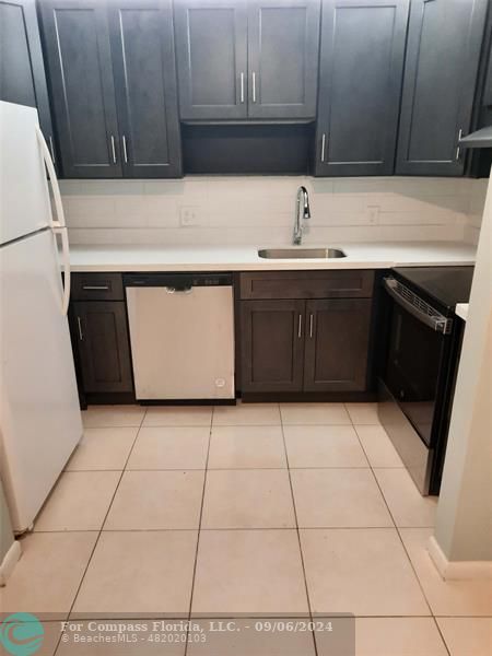 a kitchen with a sink and a stove top oven