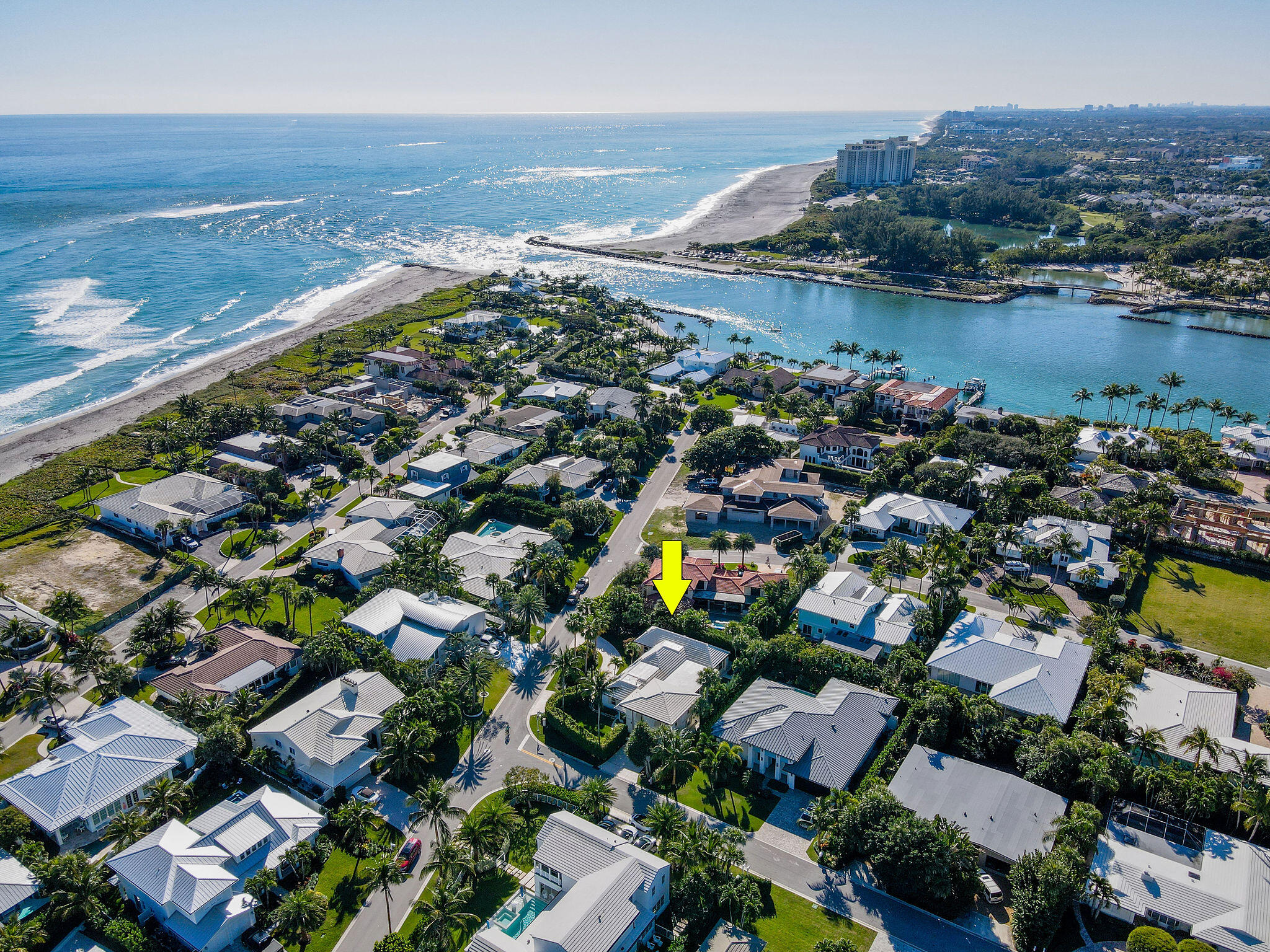 an aerial view of ocean and residential houses with outdoor space