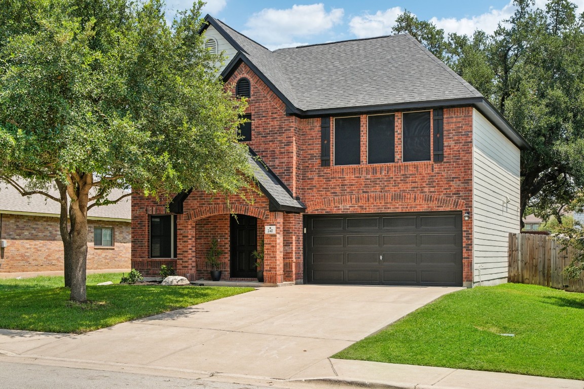 a front view of a house with a garden and trees