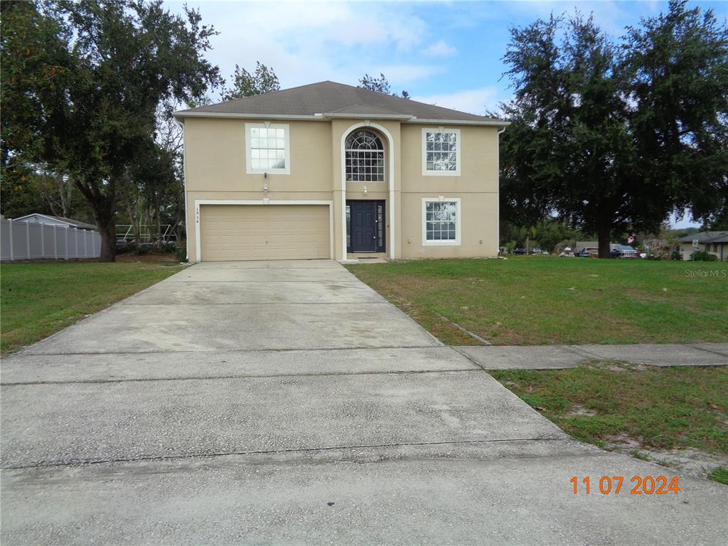 a front view of a house with a yard and garage