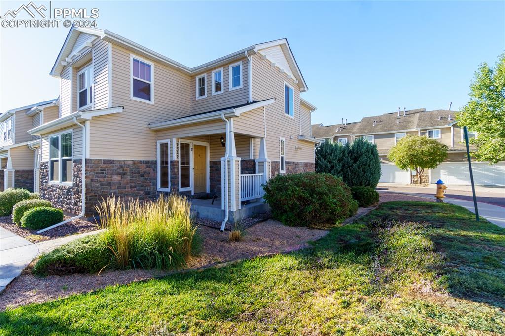 Multi unit property featuring a front lawn and covered porch