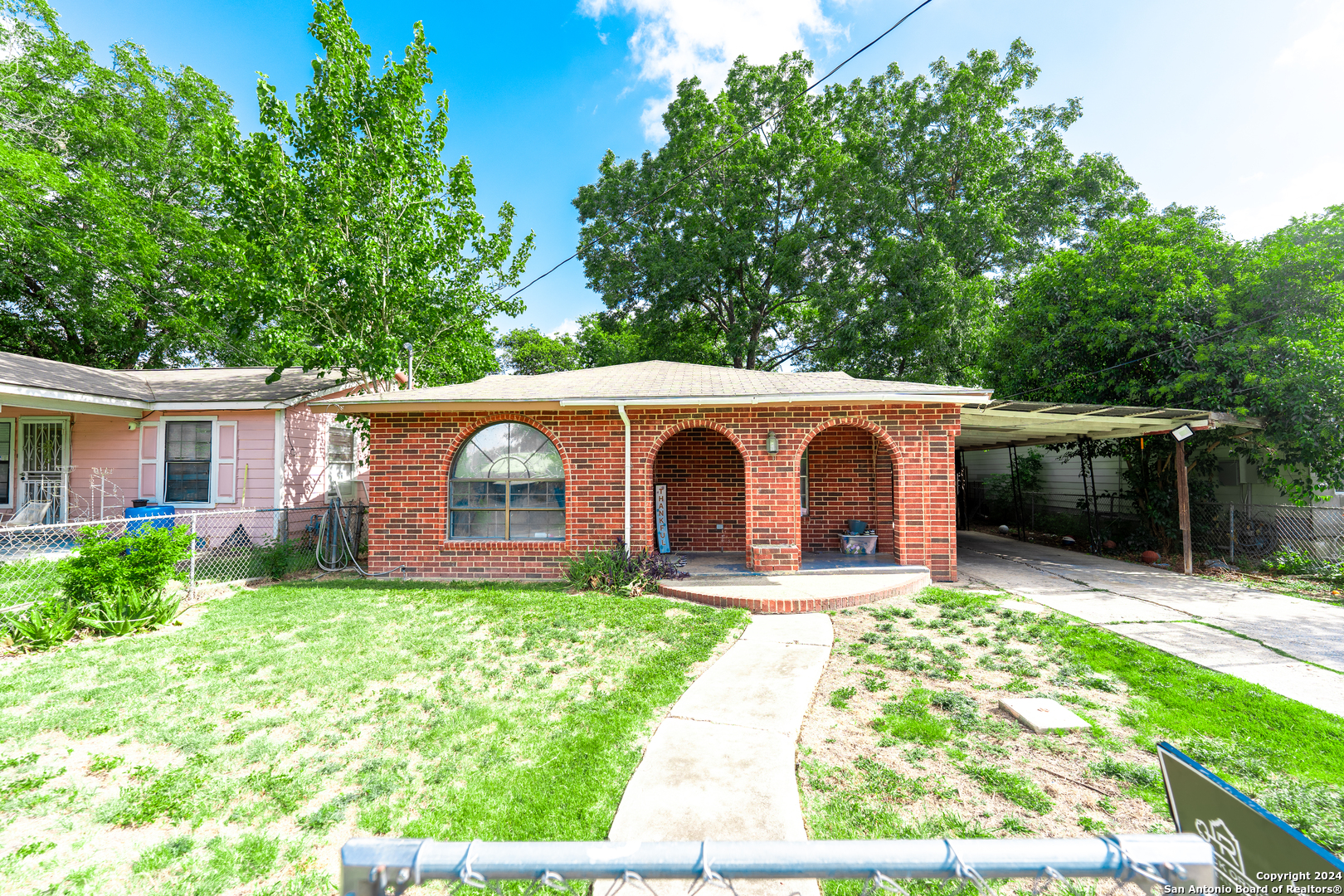 a view of a house with a yard and large tree