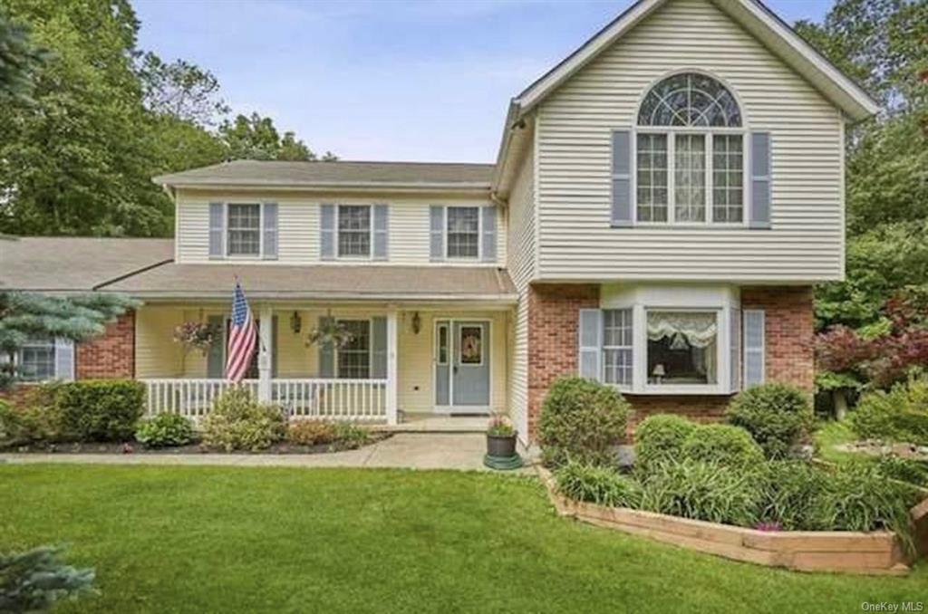 View of front of home with covered porch and a front yard