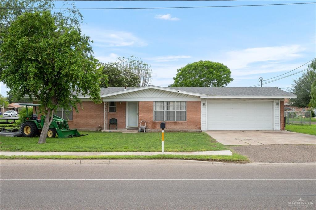 Single story commercial residence with a front lawn and a garage