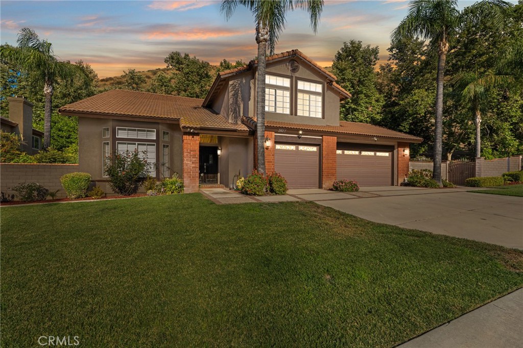 a front view of a house with a yard and palm trees