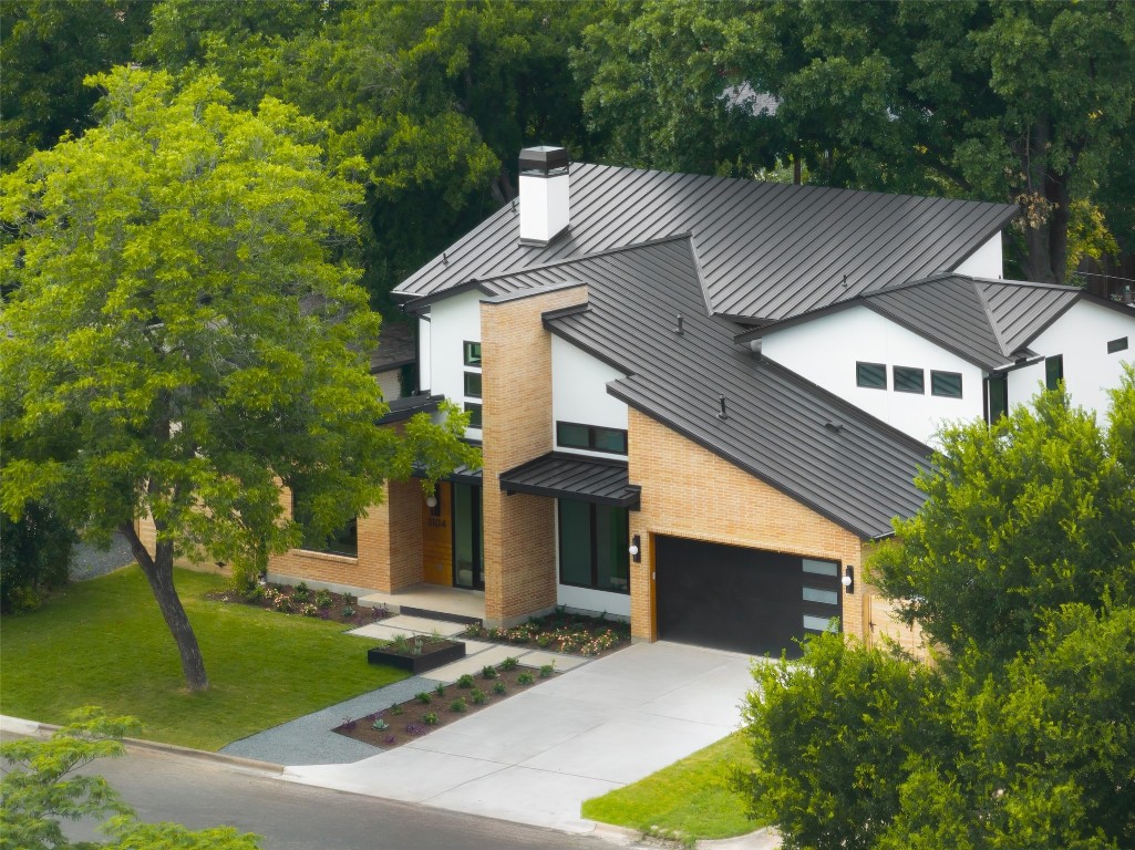 a aerial view of a house with yard and trees