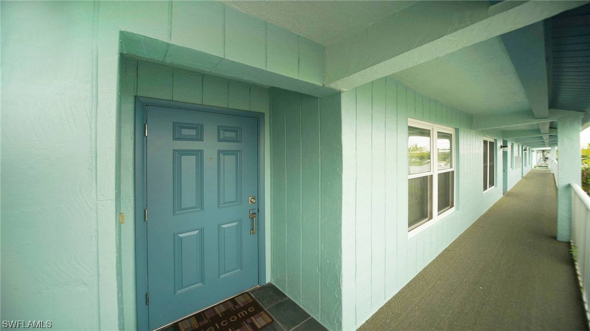 a view of a hallway with wooden floor and a bathroom