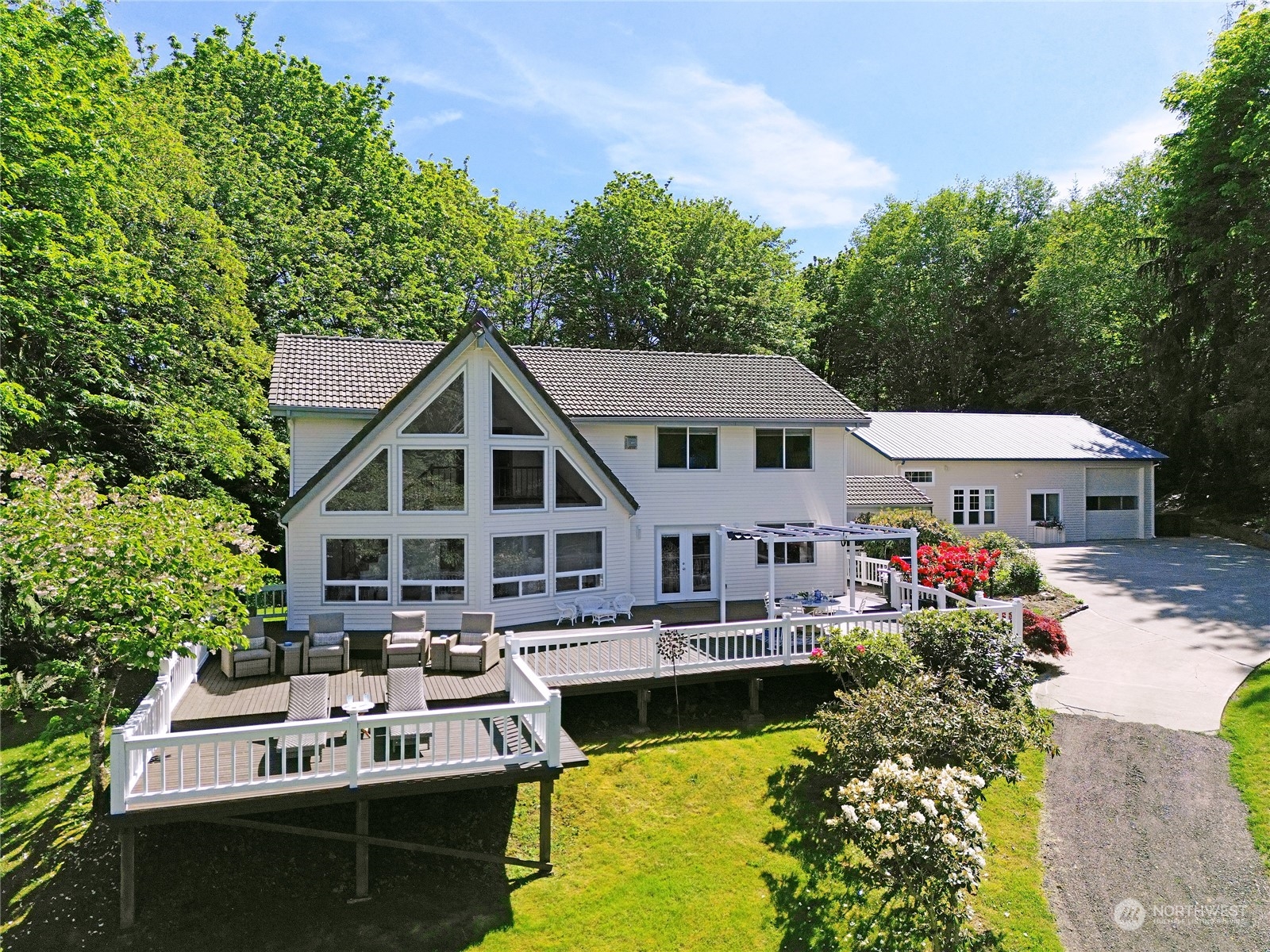 a view of a house with pool lawn chairs and a yard