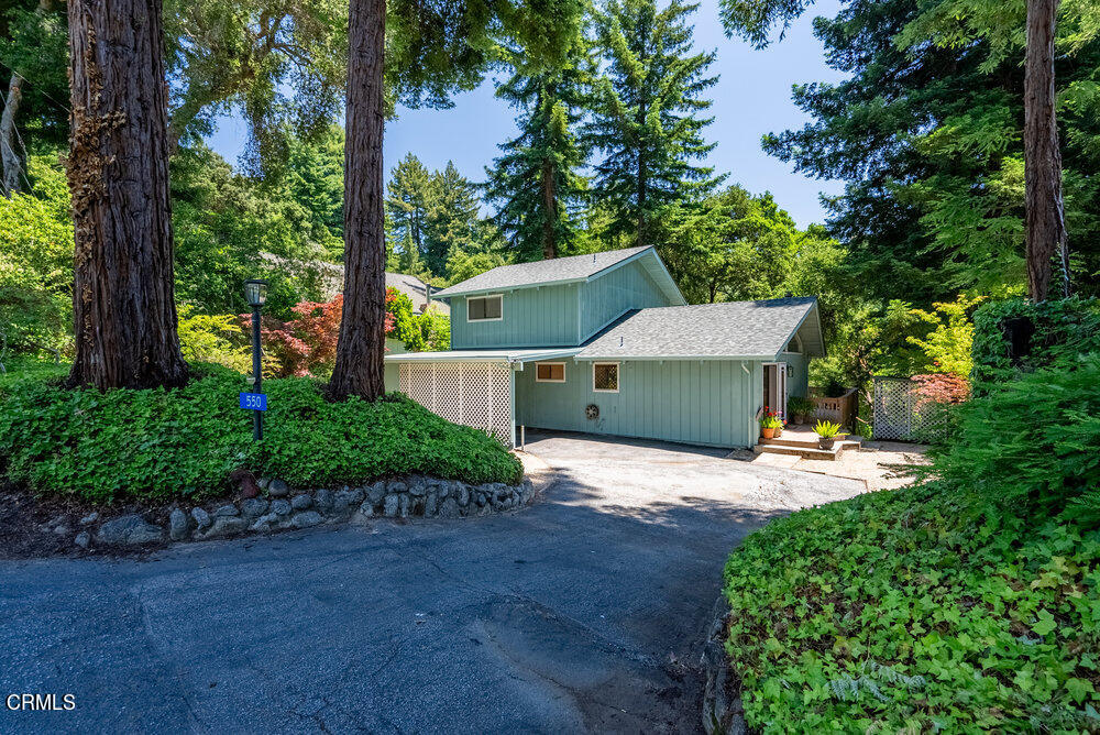 a view of a house with large tree and plants