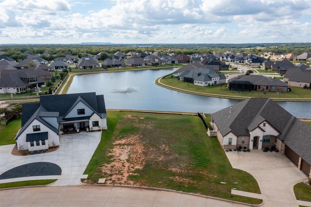 an aerial view of a house with a garden and lake view