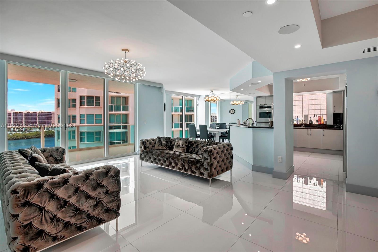 a living room with furniture a large window and a chandelier