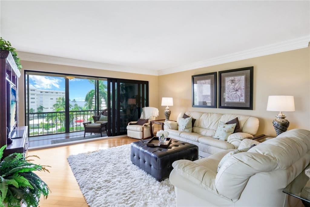 Living room featuring a healthy amount of sunlight, ornamental molding, and hardwood / wood-style flooring