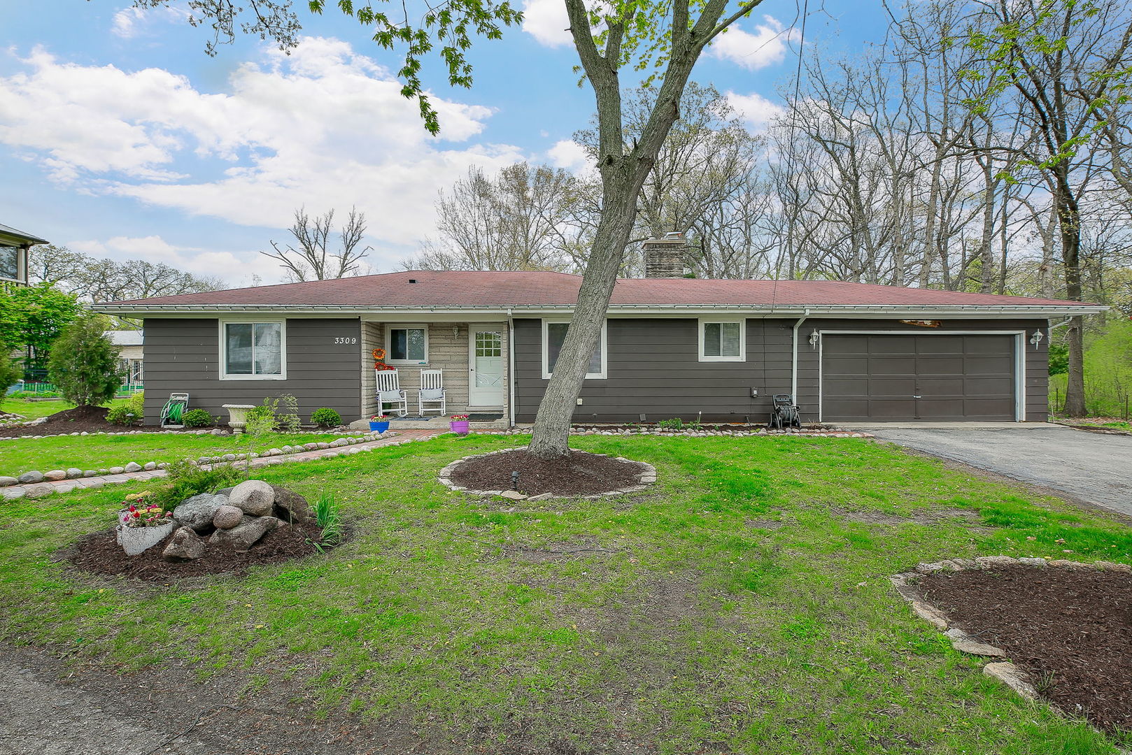 a front view of a house with a yard and green space