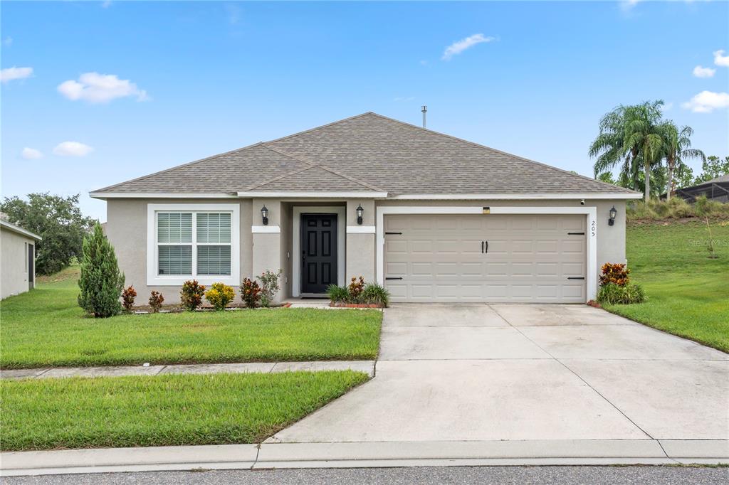 a front view of a house with a yard and garage