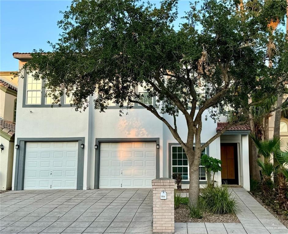 a front view of a house with a tree