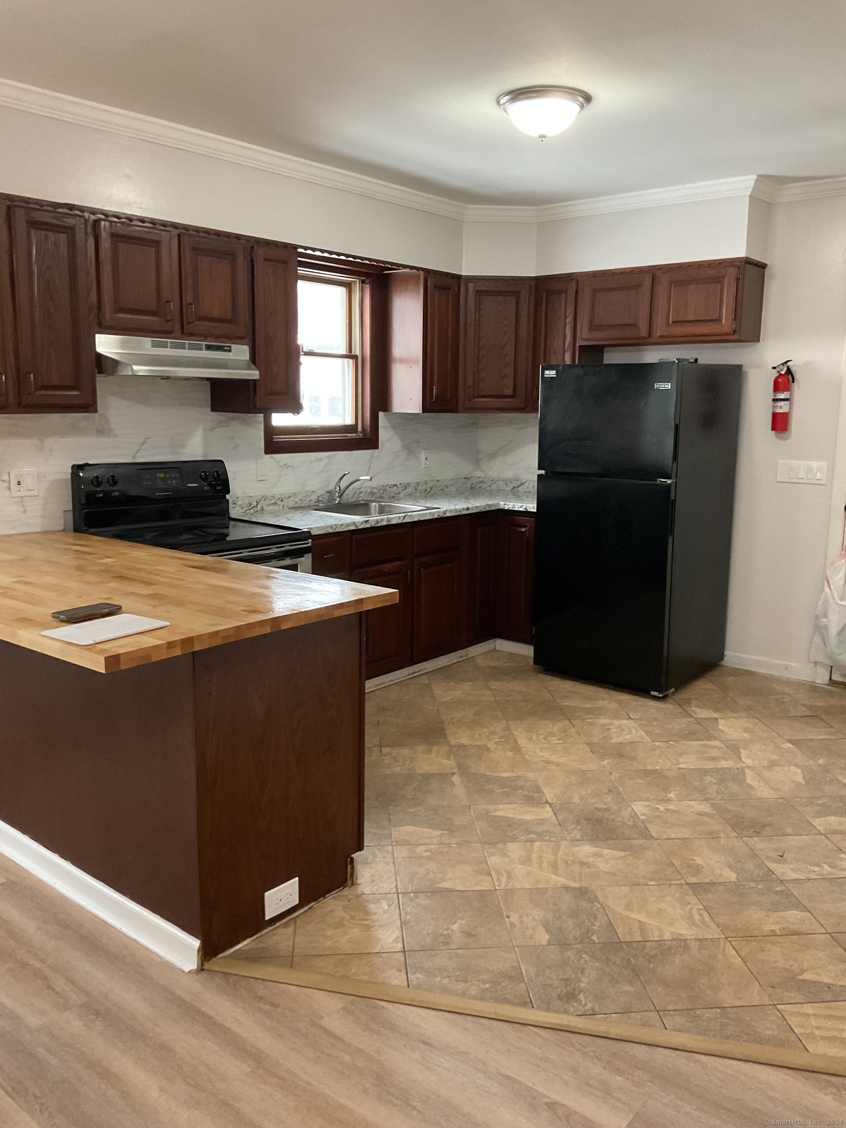 a kitchen with granite countertop a refrigerator and a stove top oven