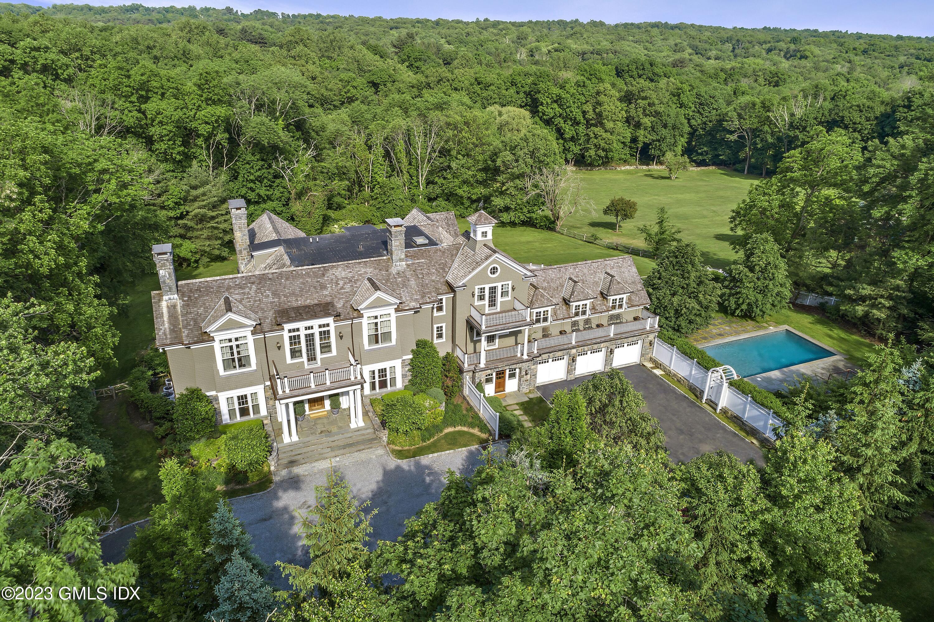 an aerial view of residential houses with outdoor space and trees all around