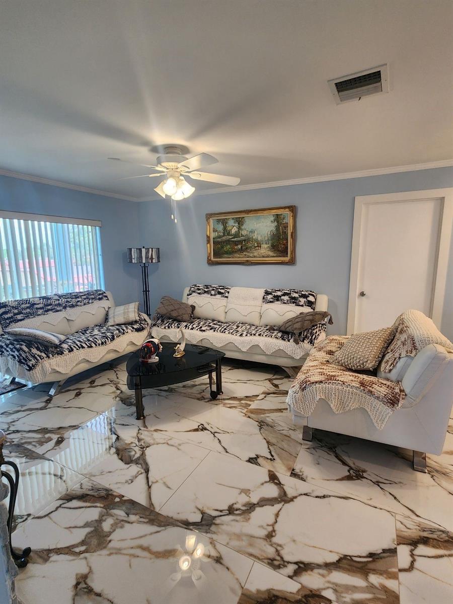 a living room with furniture and a ceiling fan