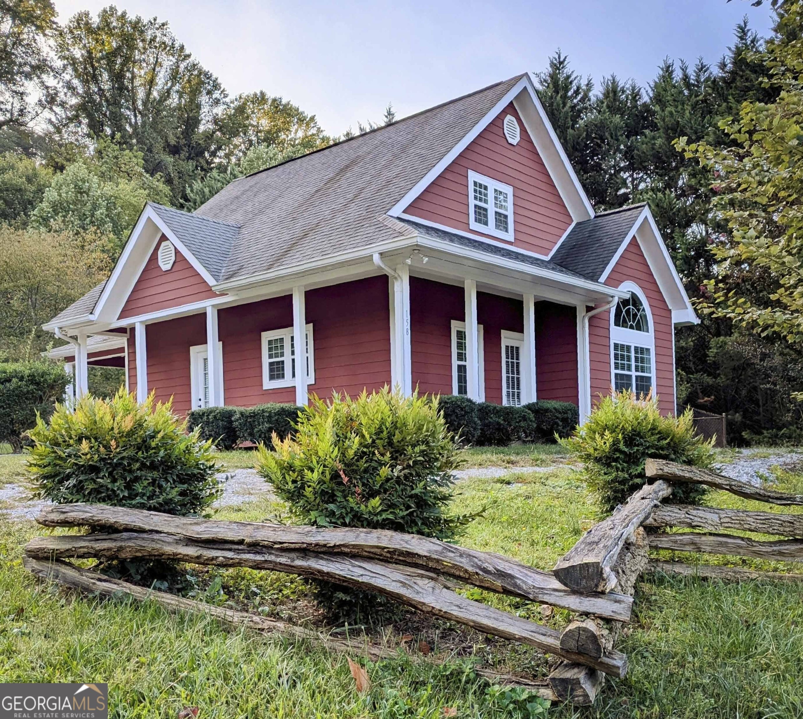 a front view of a house with yard and green space