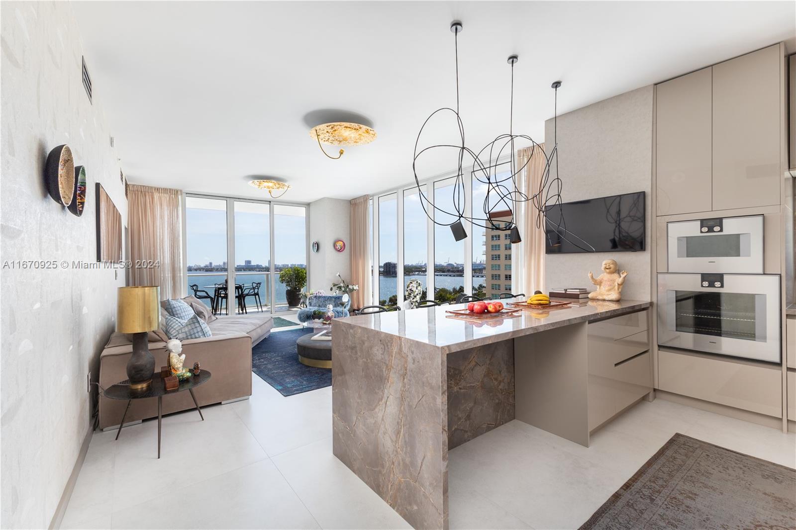 a living room with stainless steel appliances kitchen island granite countertop a stove and a sink