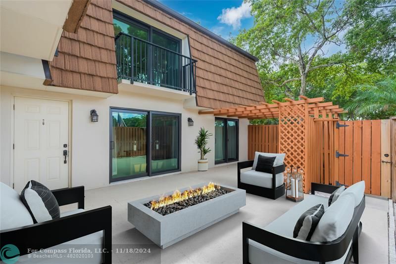 a view of a patio with couches and a dining table and chairs with wooden floor