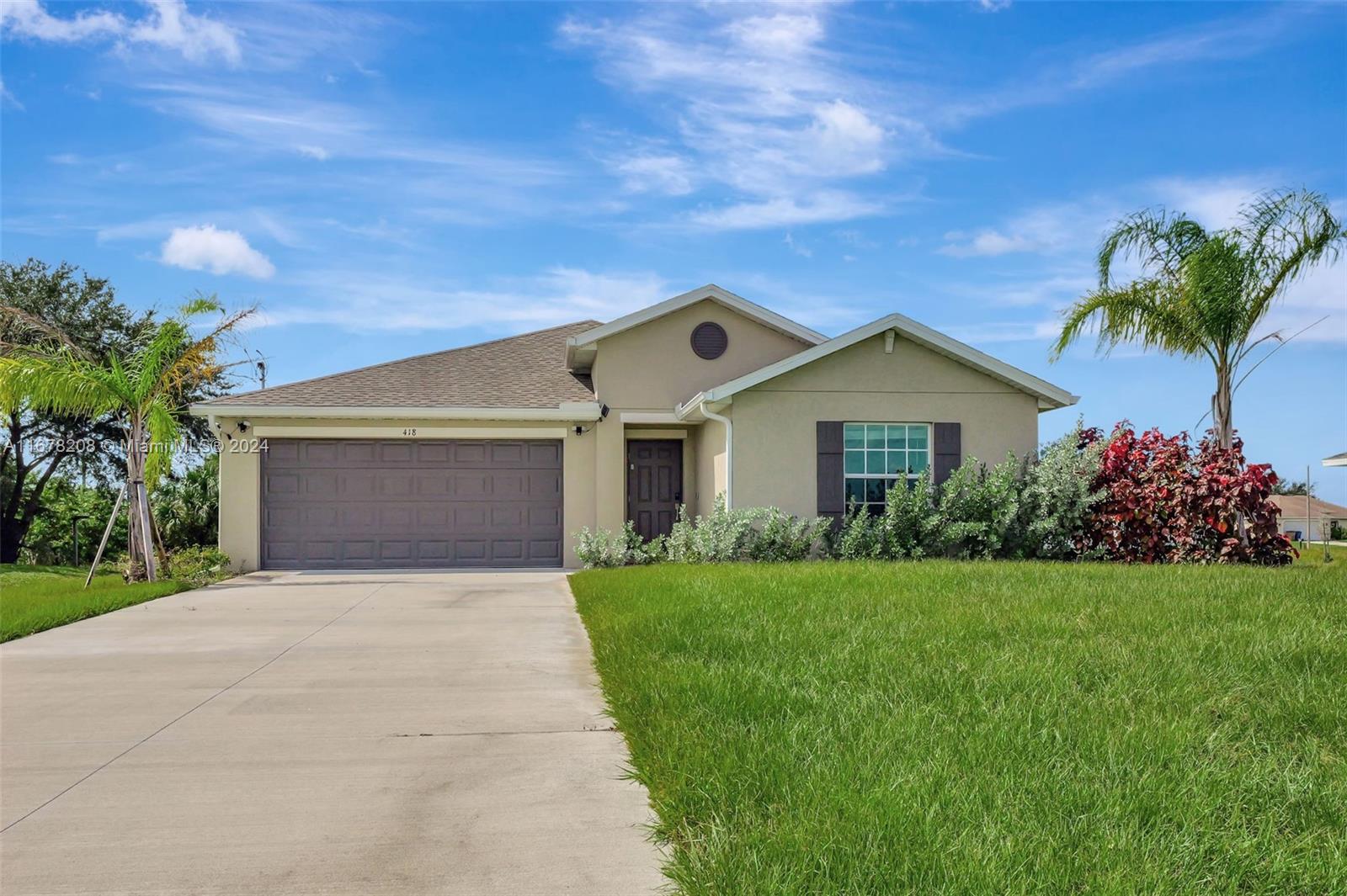 a front view of a house with a yard and garage