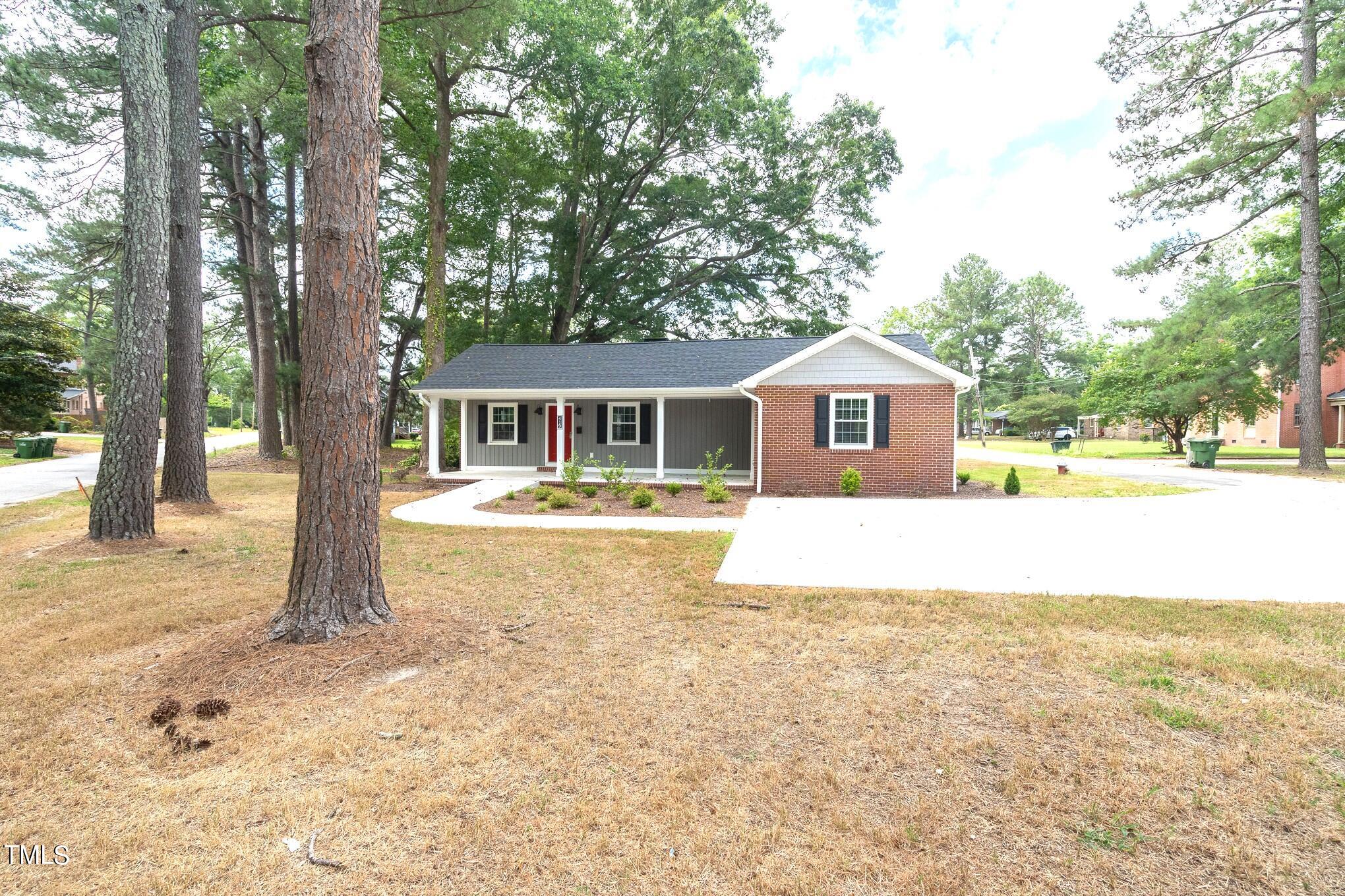 a front view of a house with a yard and trees