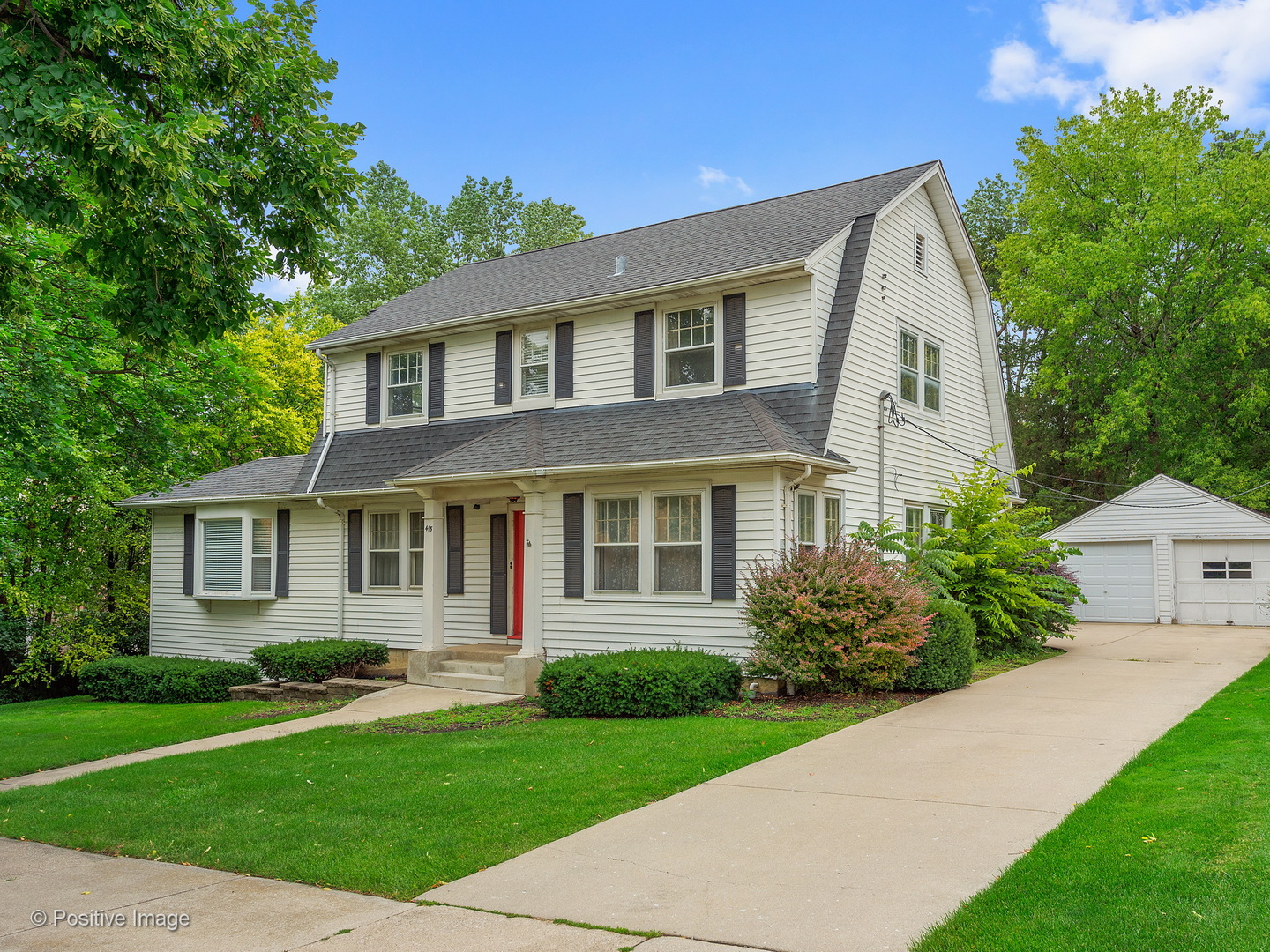 a front view of a house with a yard and potted plants