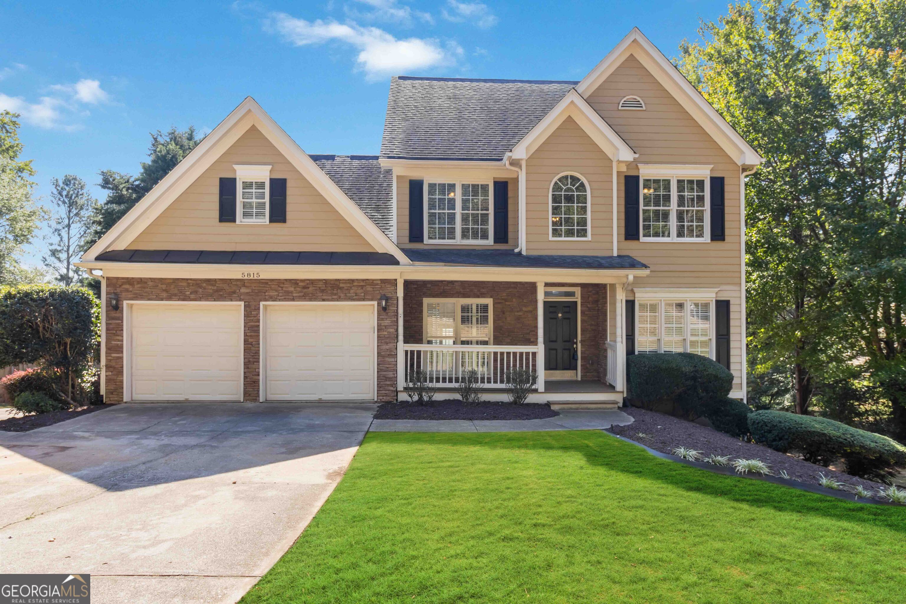 a front view of a house with a yard and garage