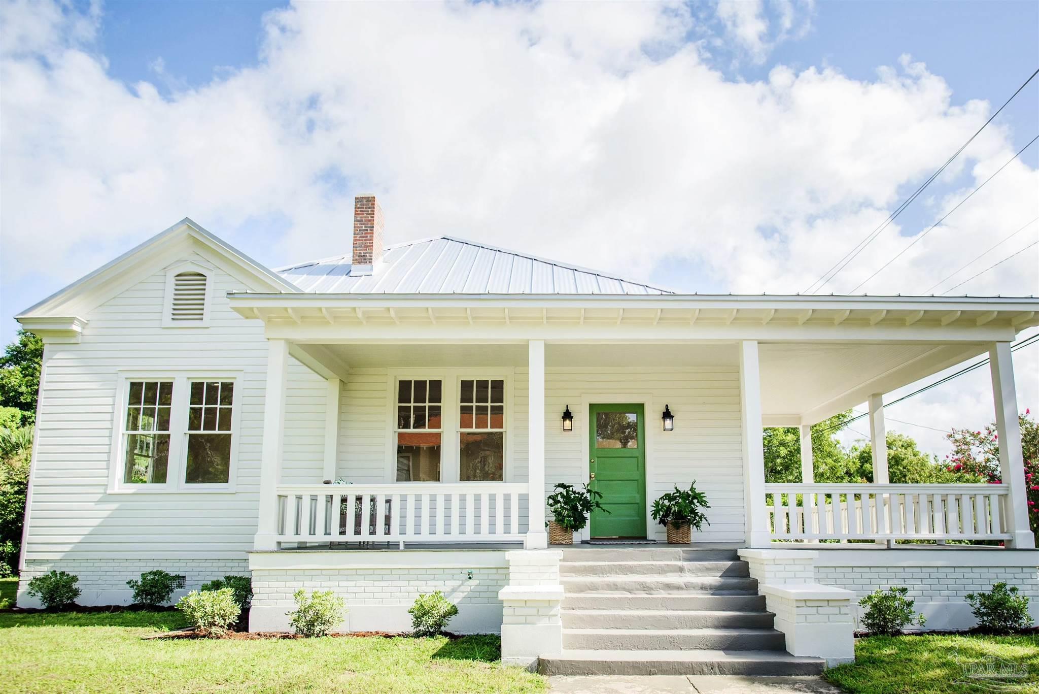 a front view of a house with a garden and yard