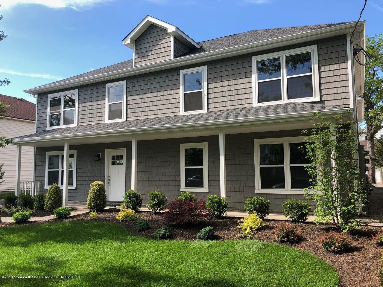 a front view of a house with porch and garden