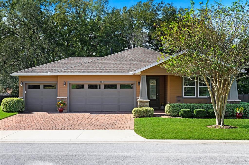 a front view of a house with a garden and trees