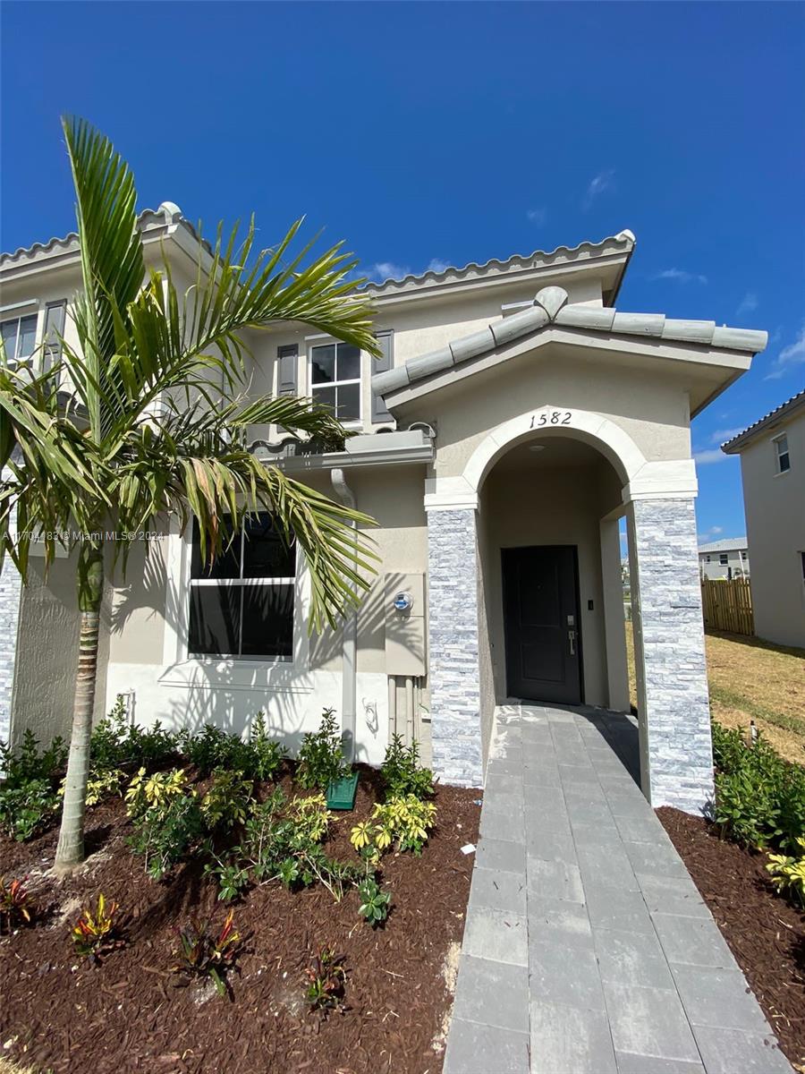 a front view of a house with plants