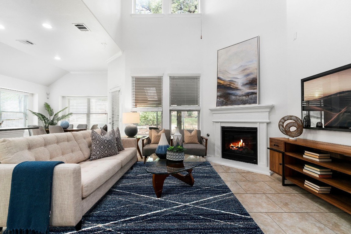 The open living areas soaring ceilings and clerestory windows provide abundant natural light and are complemented by a cozy fireplace and tile flooring.