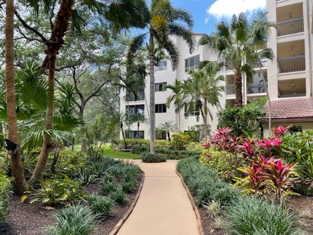 a view of flower garden with multi story residential apartment building in front of it