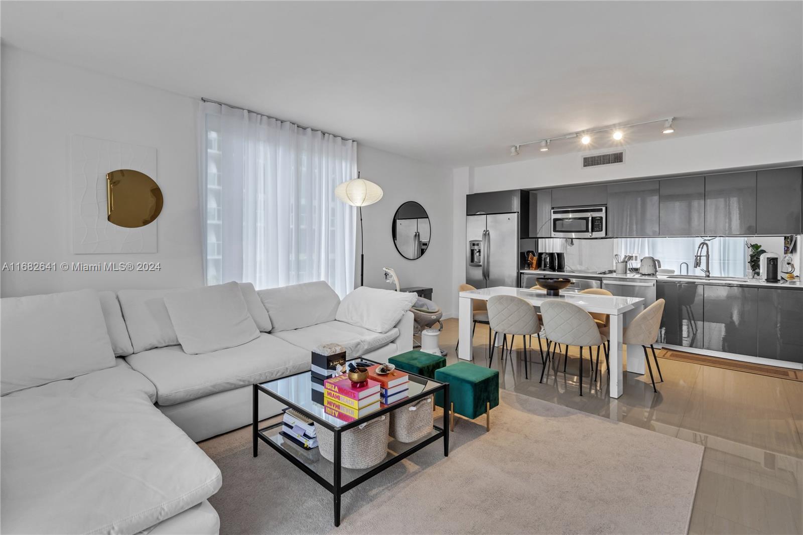 a living room with furniture kitchen view and a window