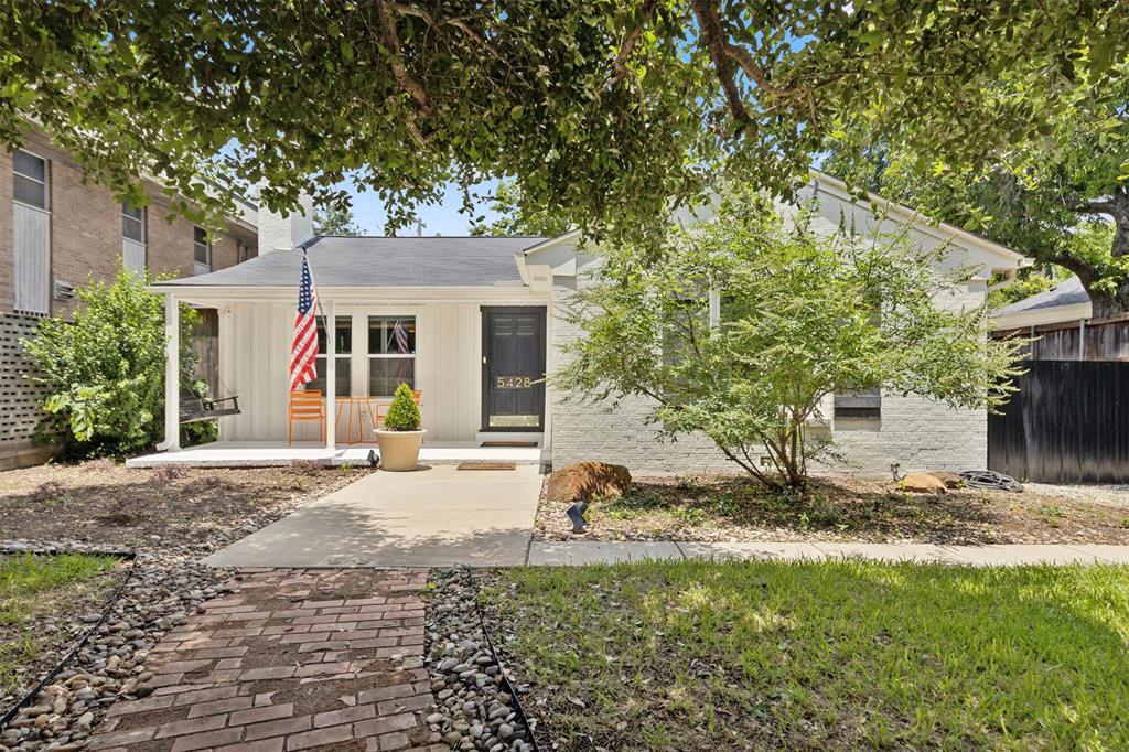 a view of a house with backyard and trees