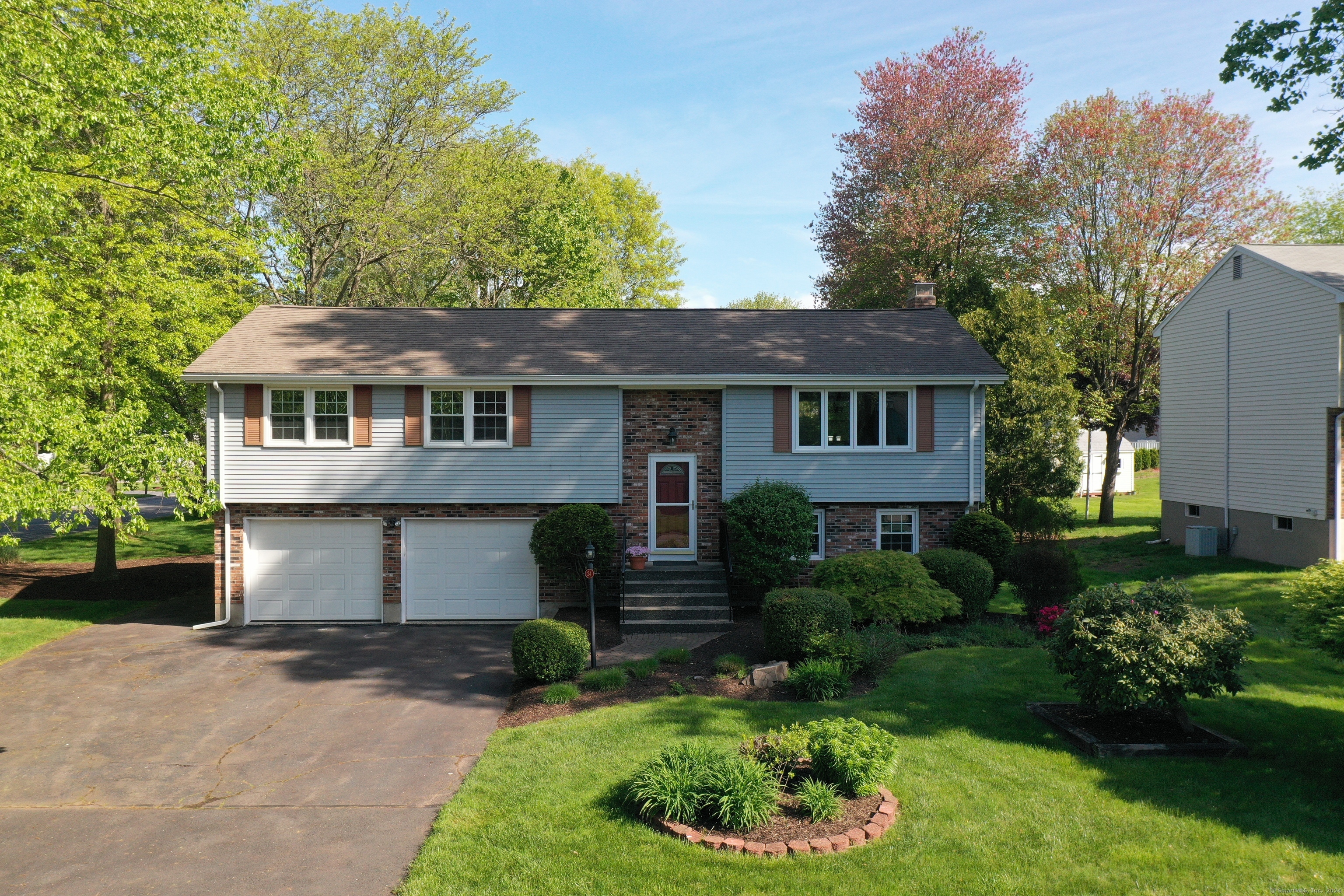 a front view of a house with a garden and plants