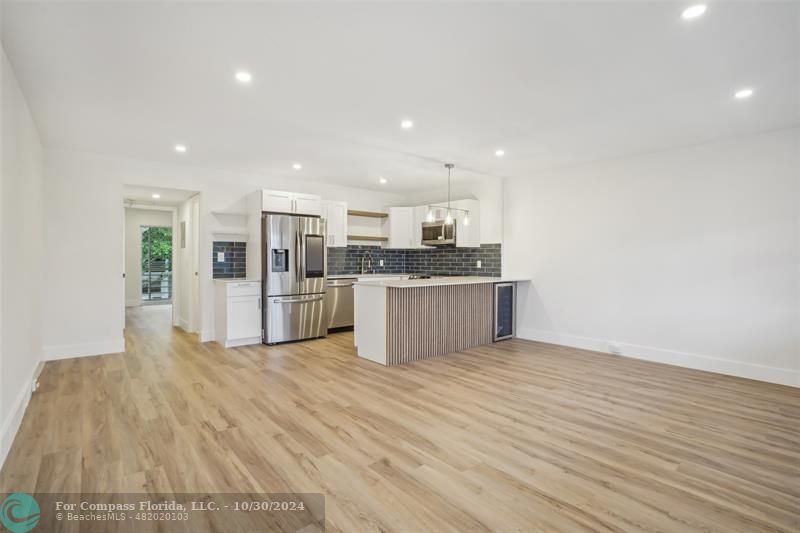 a large kitchen with stainless steel appliances granite countertop a large counter top and a stove top oven