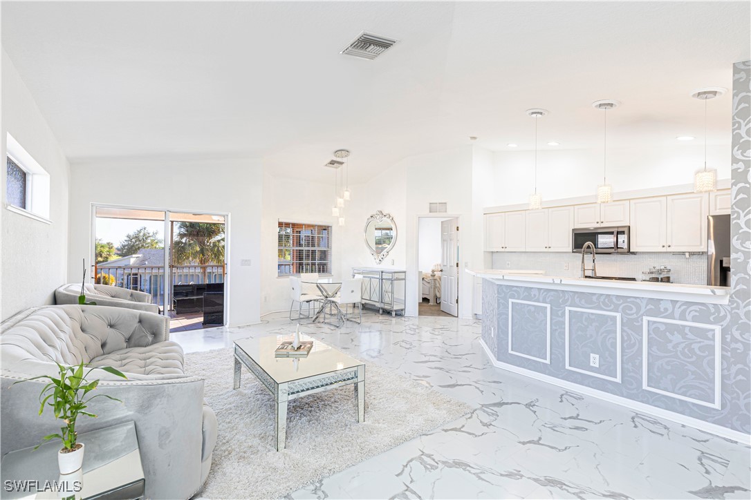 a living room with kitchen island furniture and a kitchen view